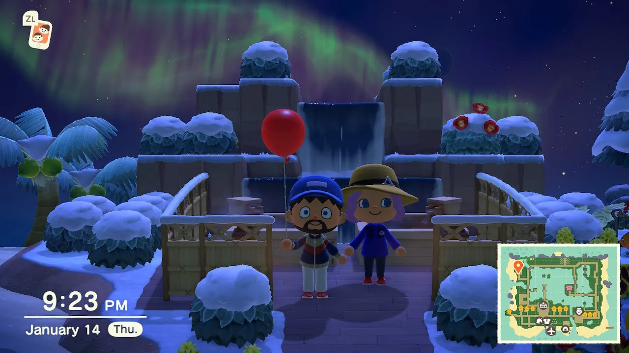 Todd and Mary standing at the island's tiered waterfall at night, under an aurora.