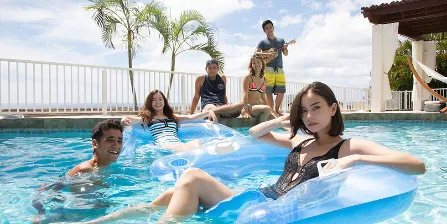 The Aloha State cast lounging in and around the pool at the house above the Pacific in Hawaii.