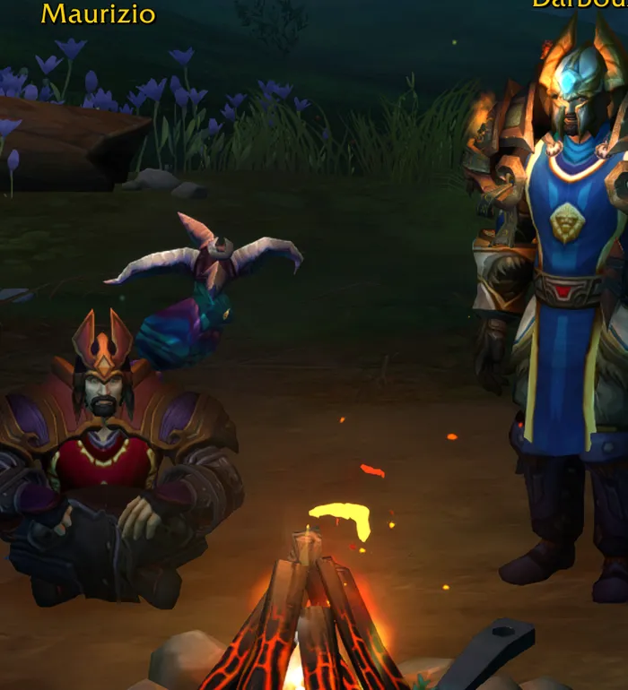 My World of Warcraft human warlock Maurizio on the character-select screen, standing by a campfire.