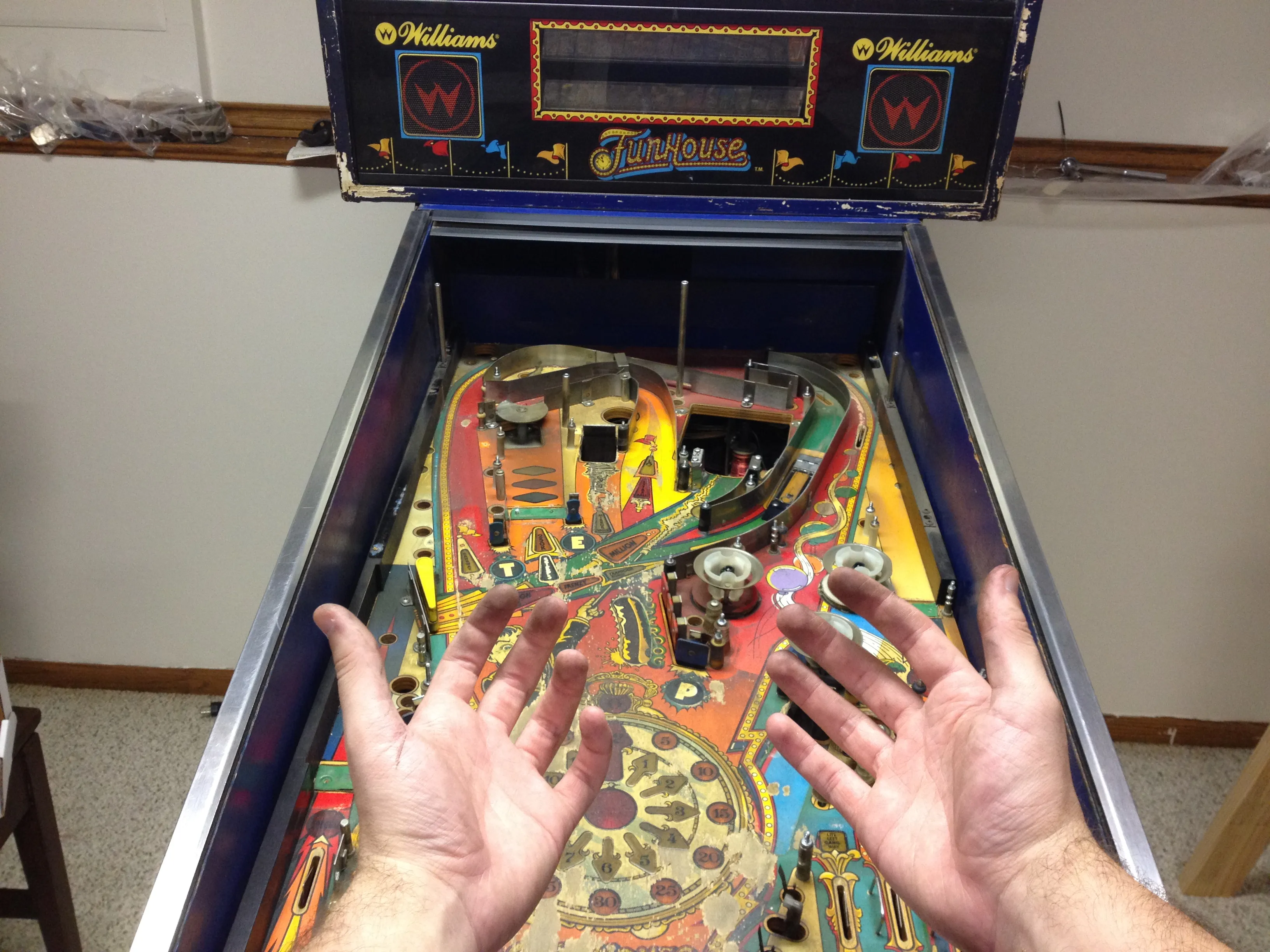 Black hands over a half-stripped, very dirty playfield